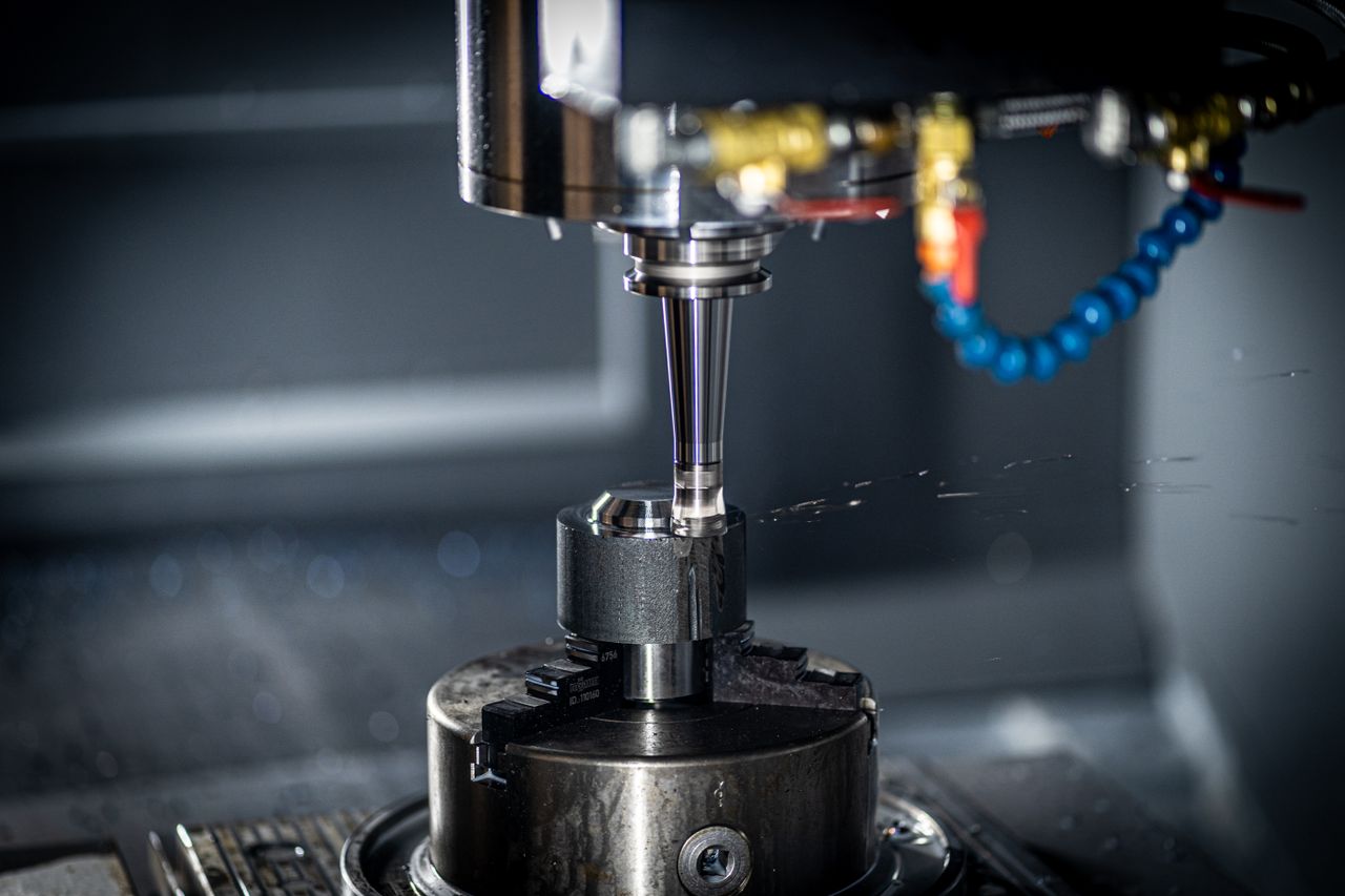 Home Close-up of CNC machine in action, showcasing precision engineering and industrial equipment.